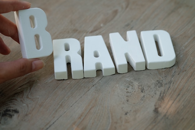 Free Photo hand arrange white letters brand