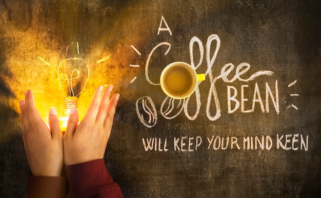 Free Photo hand covering the illuminated light bulb with message on chalkboard