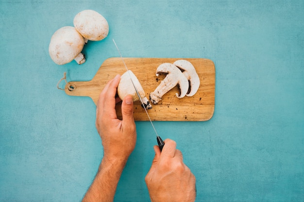 Hand cutting mushroom in slices