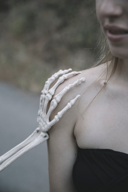 Hand of decorative skeleton touching woman's shoulder