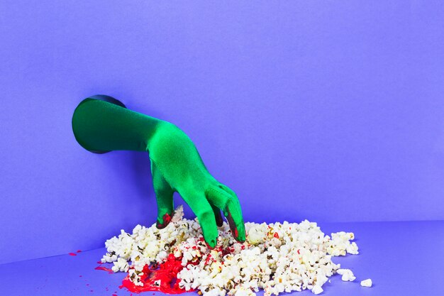 Hand from wall and pile of popcorn