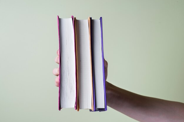 Hand grabbing three books