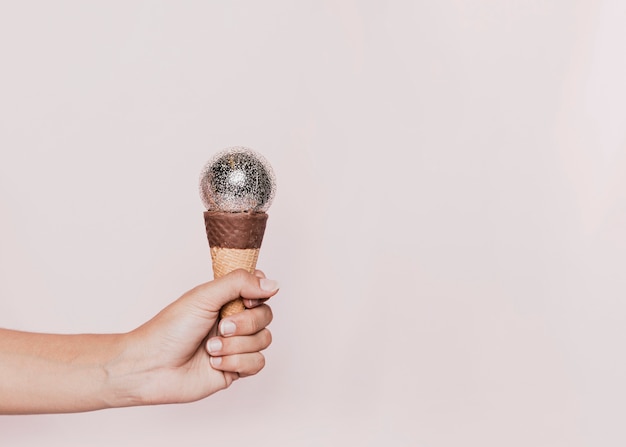 Free photo hand held ice cream cone at new years party