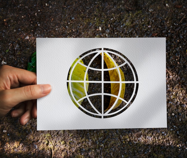 Free photo hand hold globe paper carving with leaves background