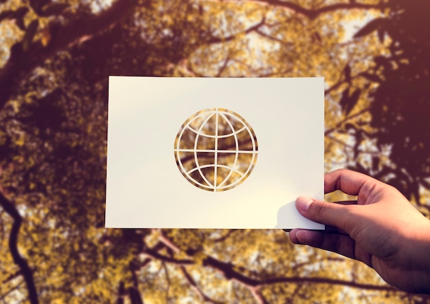 Free photo hand hold globe paper carving with nature background