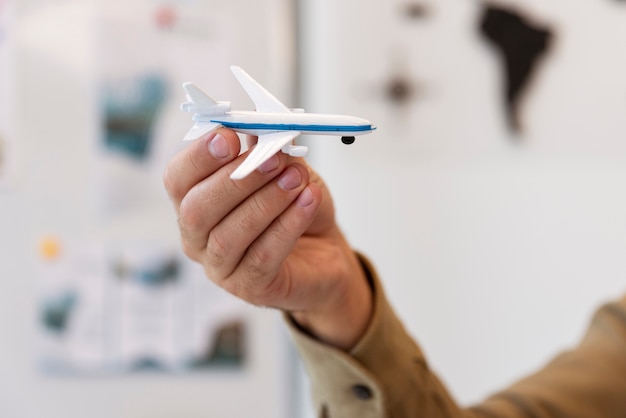 Free photo hand holding airplane toy