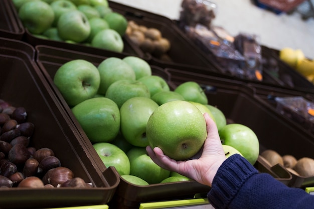 Hand holding apple in store