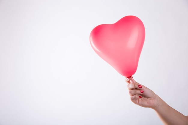 Hand holding balloon in hearts form