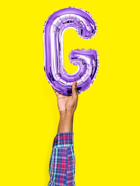 Free Photo hand holding balloon letter g