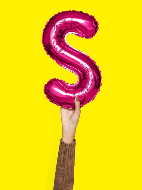 Free photo hand holding balloon letter s