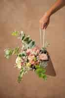 Free photo hand holding beautiful boho flowers arrangement