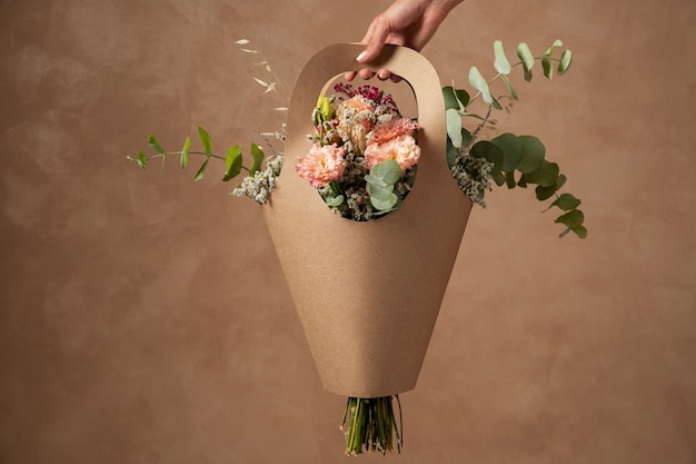 Hand holding beautiful flowers basket