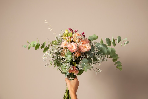 Free photo hand holding beautiful flowers bouquet