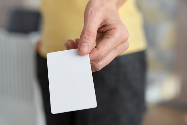 Hand holding blank business card high angle