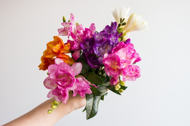 Free photo hand holding bouquet of flowers