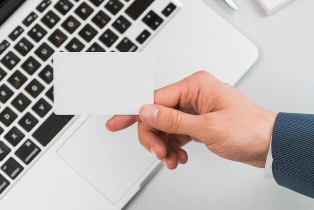 Hand holding business card in office environment