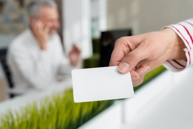 Hand holding business card at office