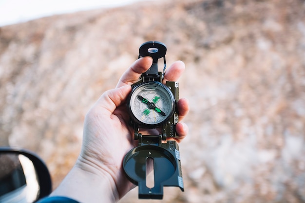 Free Photo hand holding compass at hill