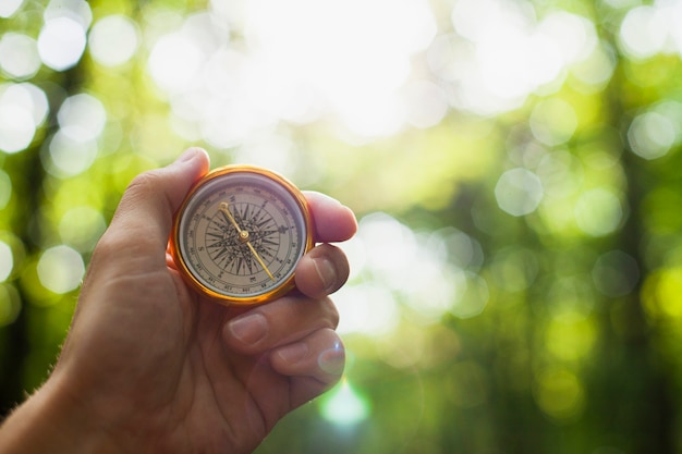 Free photo hand holding a compass with blurred background