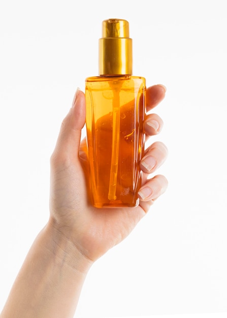 Free Photo hand holding cosmetic bottle