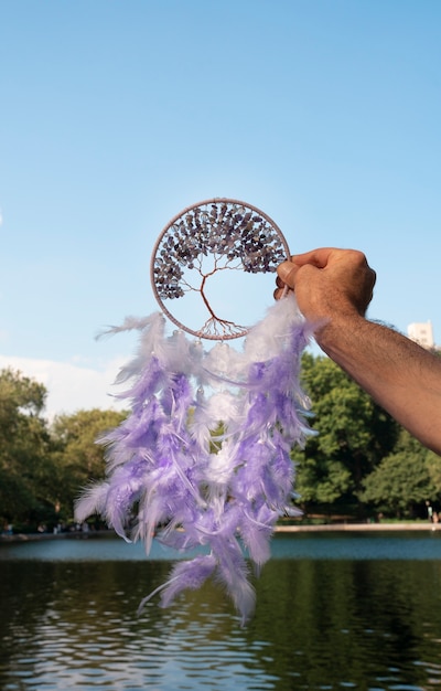 Hand holding dream catcher outdoors