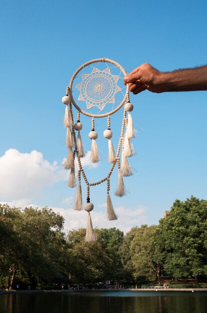 Hand holding dream catcher outdoors