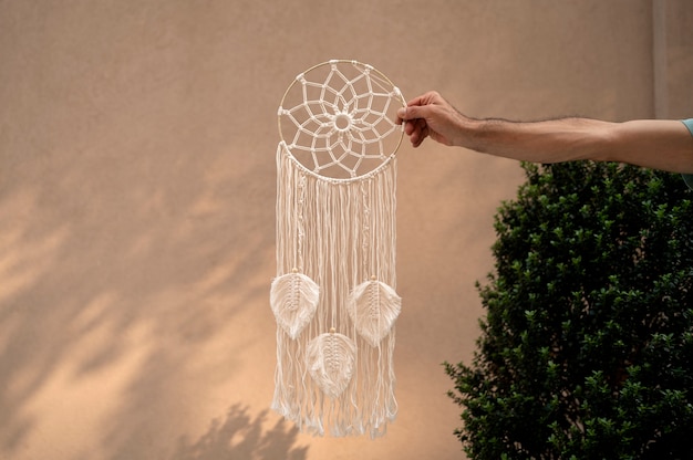 Free Photo hand holding dream catcher outdoors