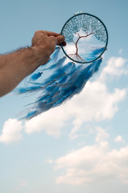 Free Photo hand holding dream catcher outdoors