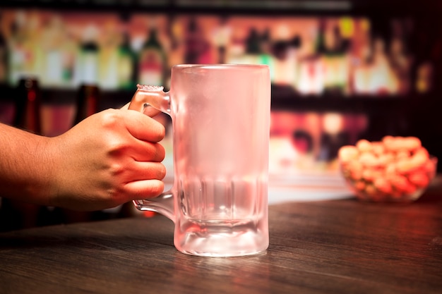 Hand holding empty beer glass