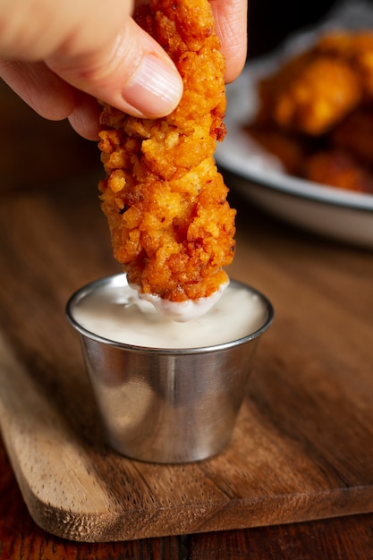 Free photo hand holding fried chicken close up