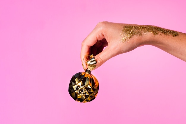 Hand holding golden decoration ball