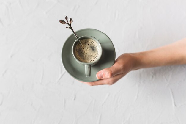 Free photo hand holding green coffee set