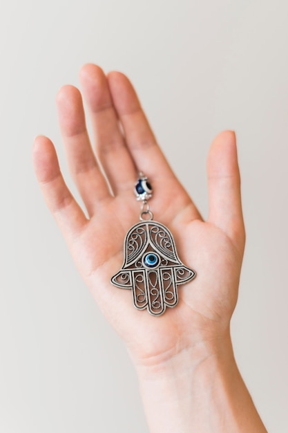 Free Photo hand holding hamsa pendant