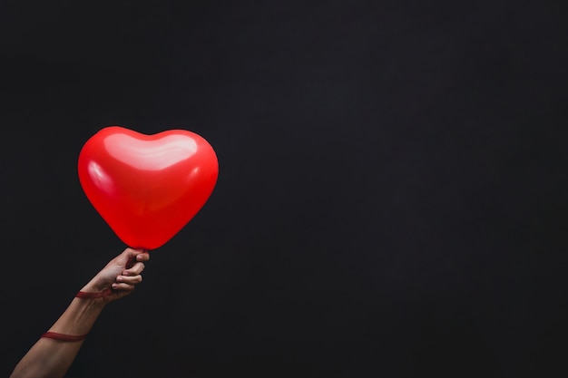 Hand holding a heart shaped balloon