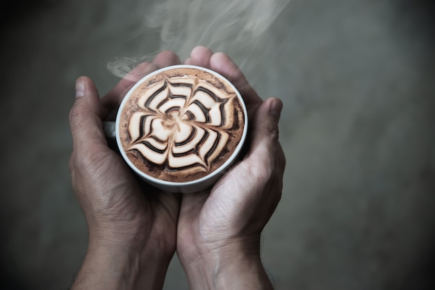 Free photo hand holding hot coffee cup