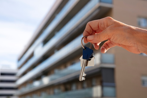 Free photo hand holding key outdoors