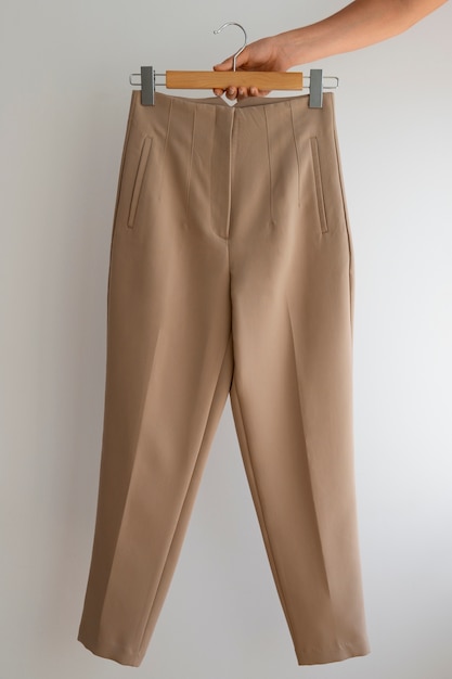 Hand holding light brown beige pants