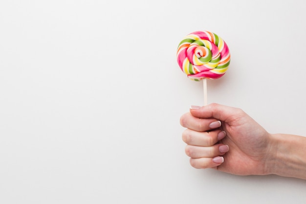 Hand holding a lollipop with copy space