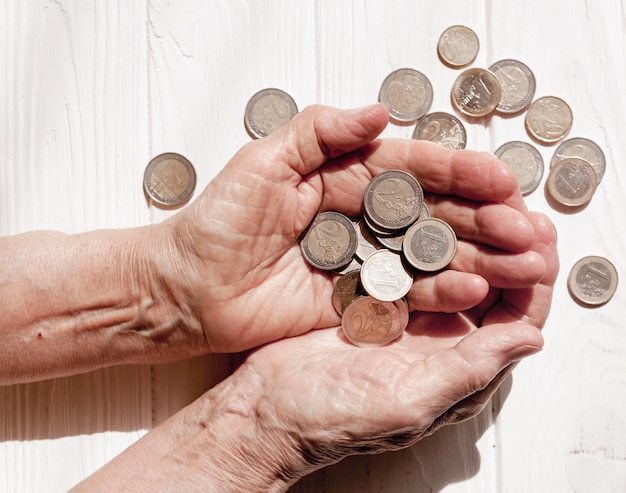 Hand holding lots of euro coins top view