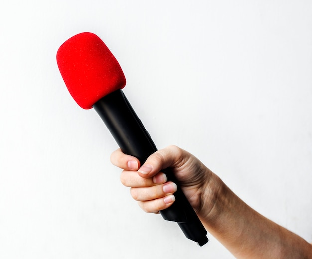 Free photo hand holding microphone isolated on background