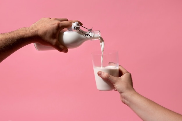 Free photo hand holding milk bottle still life