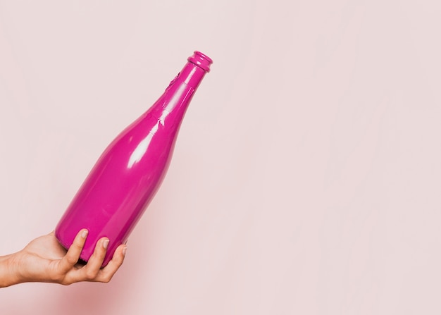 Hand holding pink champagne bottle