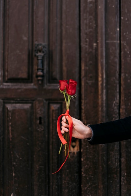 Hand holding red roses bouquet