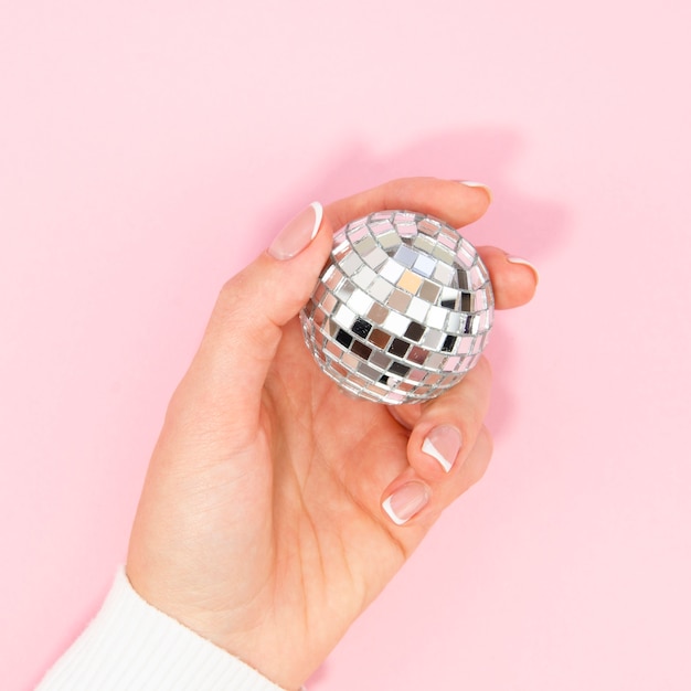 Free Photo hand holding silver disco ball