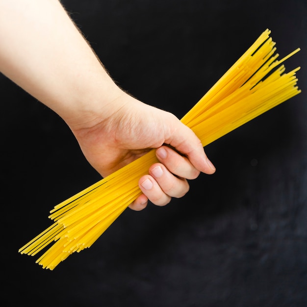 Free photo hand holding spaghetti