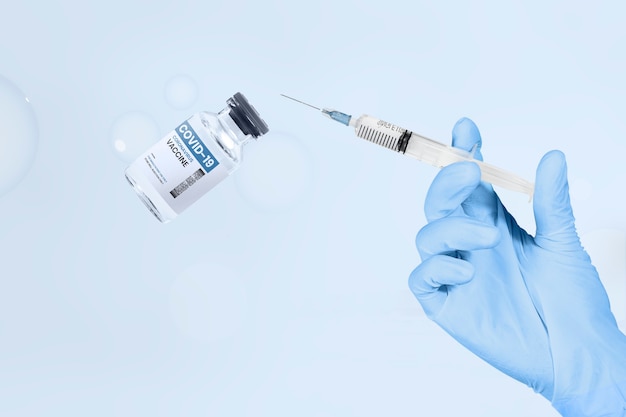 Free Photo hand holding syringe and vaccine vial