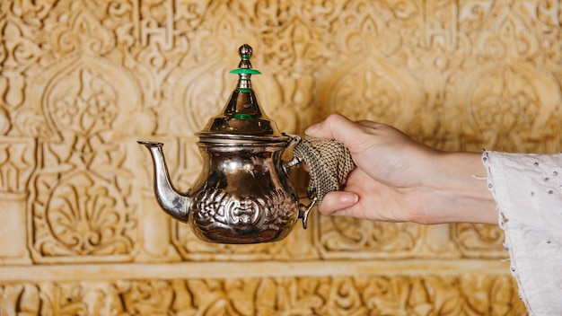 Free Photo hand holding tea pot