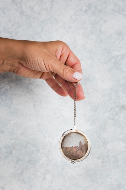 Free Photo hand holding tea strainer