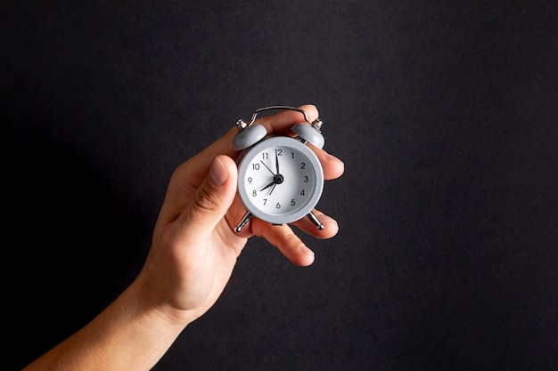 Hand holding a vintage little clock