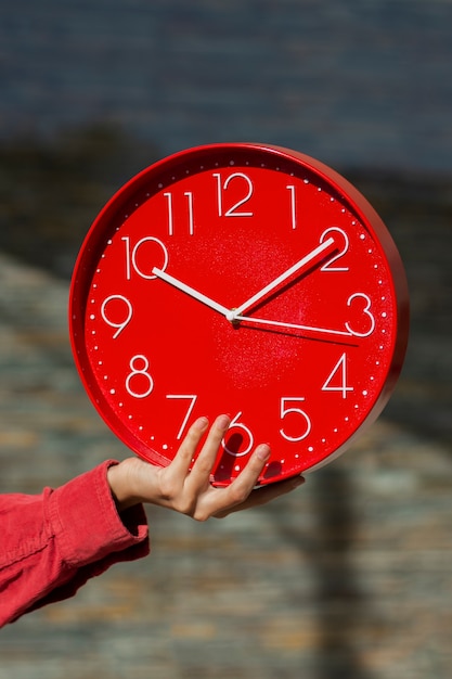 Free photo hand holding wall clock still life